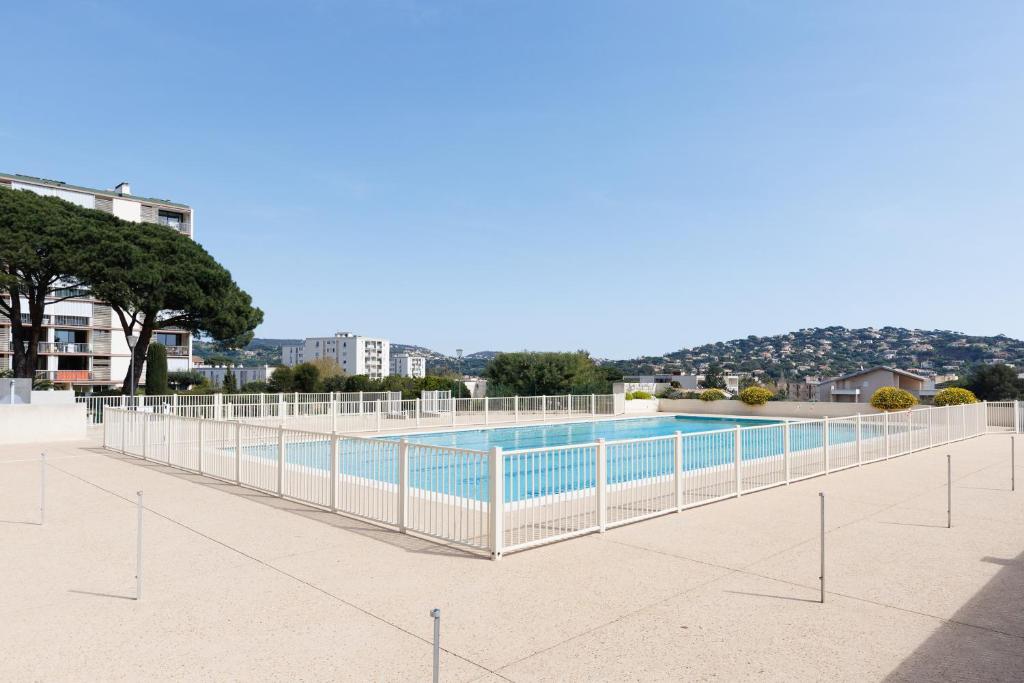 une piscine entourée d'une clôture blanche. dans l'établissement Les Coteaux Du Préconil YourHostHelper, à Sainte-Maxime