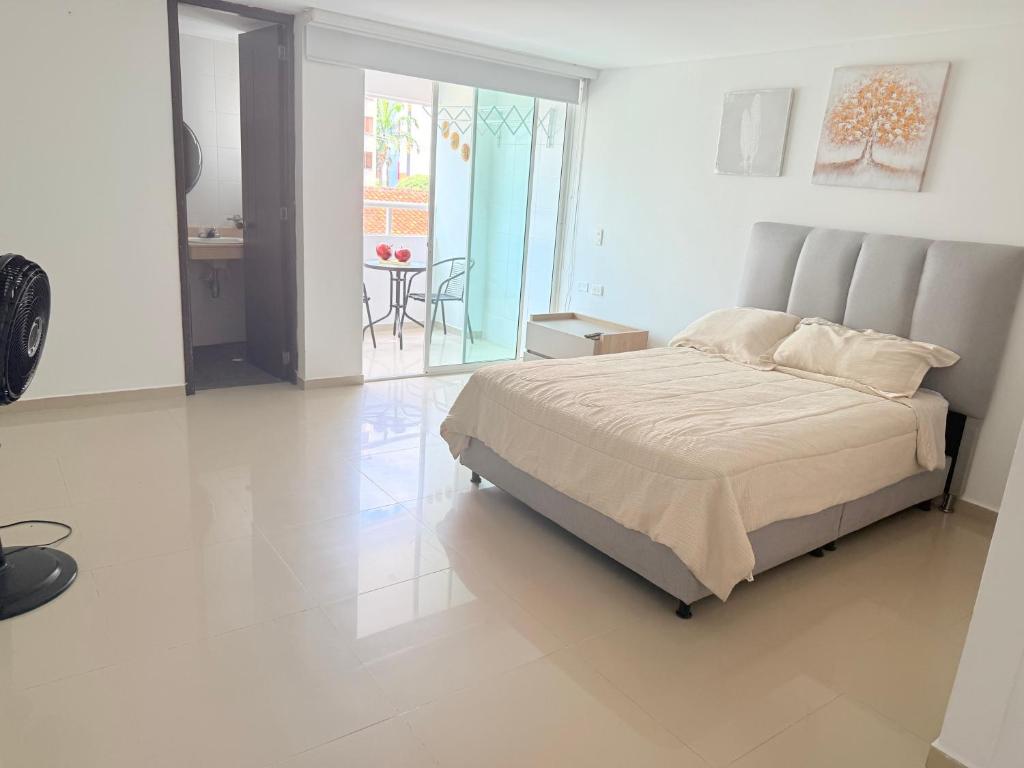 a bedroom with a large bed in a white room at APARTIESTUDIO AMOBLADO SOTOMAYOR ALQUILER RENTA HOUSe in Bucaramanga