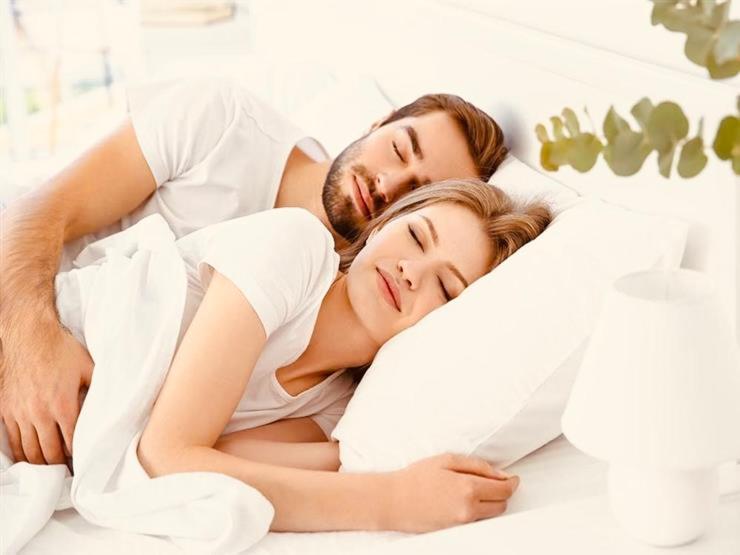 a man and a woman laying in bed at MAGIC RUM lUXURY HUSSEN in Wadi Rum