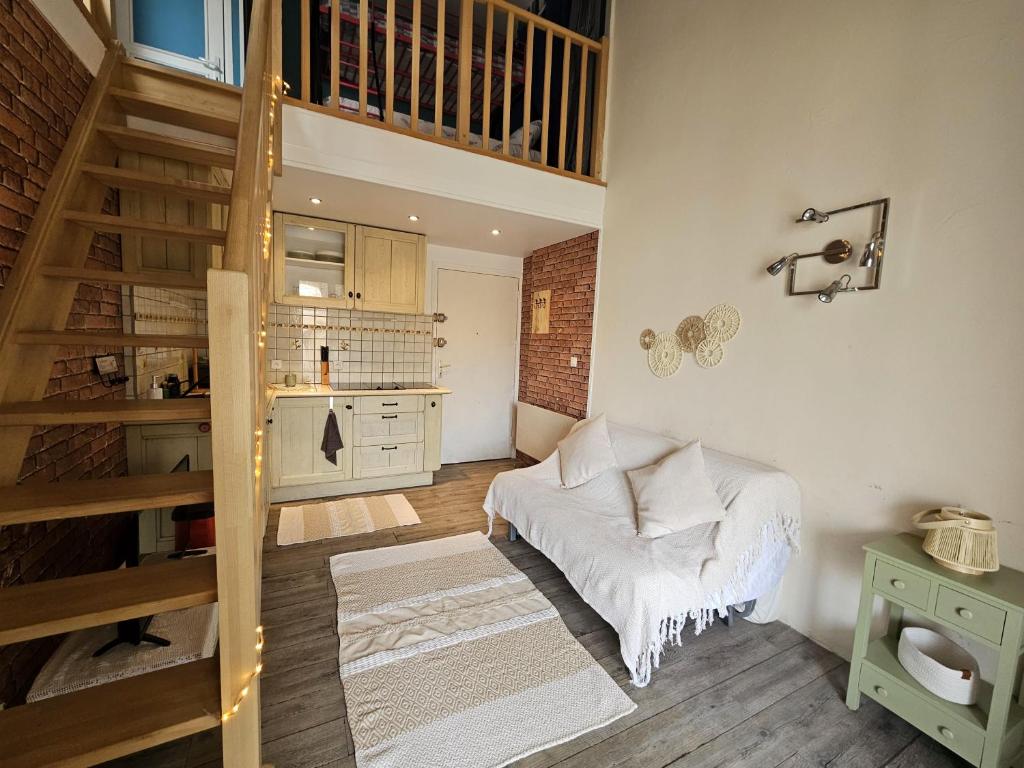 un salon avec un escalier et un canapé dans l'établissement Bel appartement face à la mer, au Barcarès