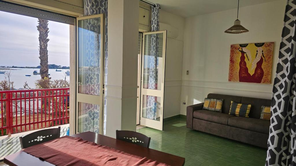 una sala de estar con una mesa y un sofá en Tramonto, en Porto Cesareo