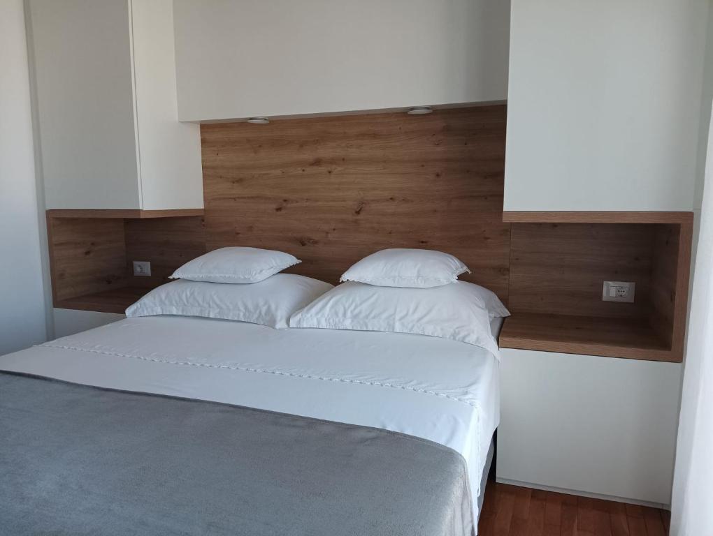 una camera da letto con due cuscini bianchi su un letto di Pluton a Primošten