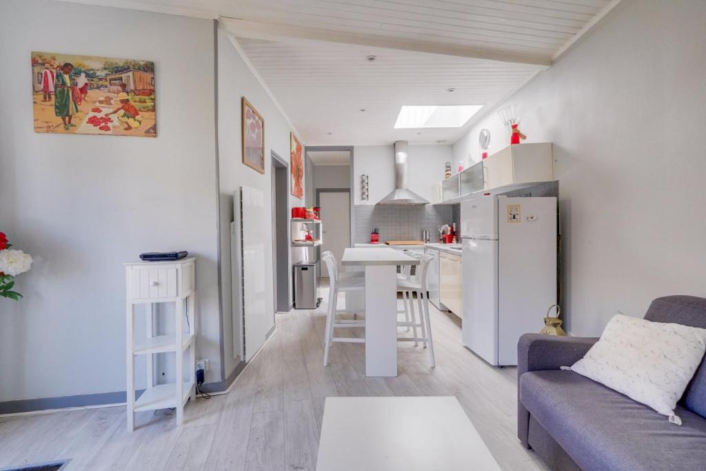 a small living room with a couch and a kitchen at Maison Papavero in La Teste-de-Buch