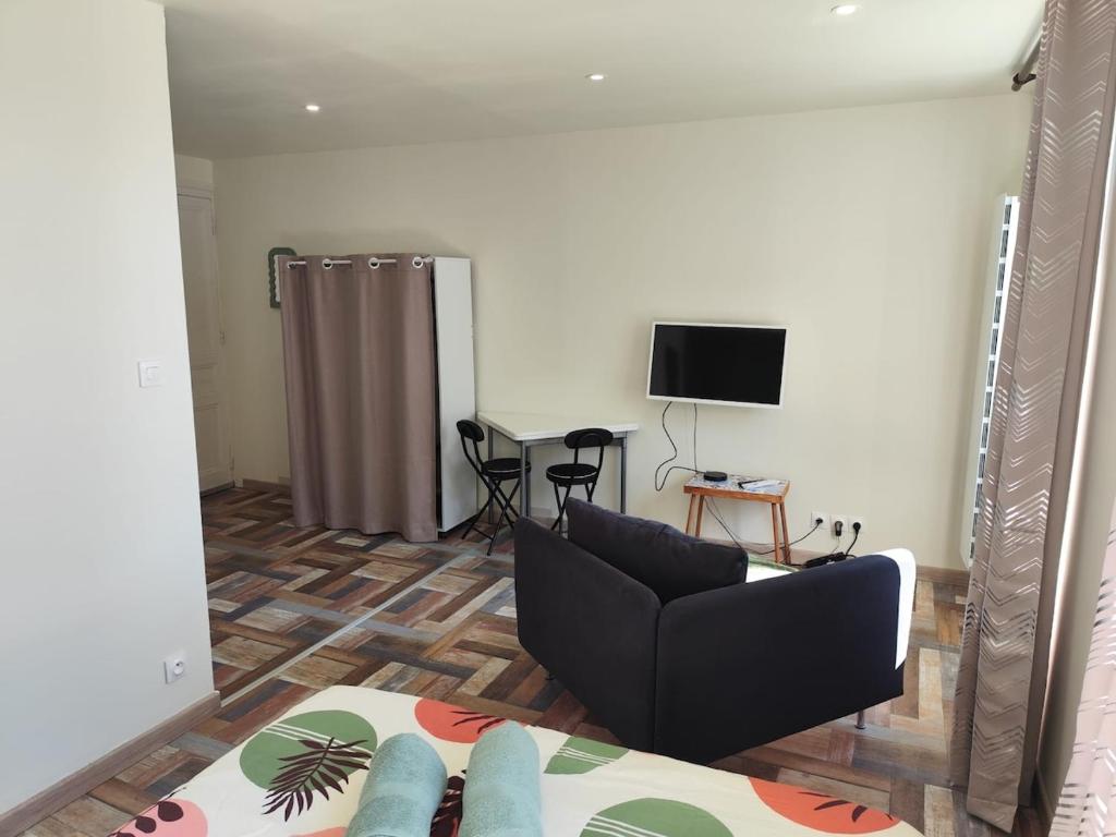 un salon avec un canapé et une télévision dans l'établissement L'ibis City By Nid 'ouest, à Quimper