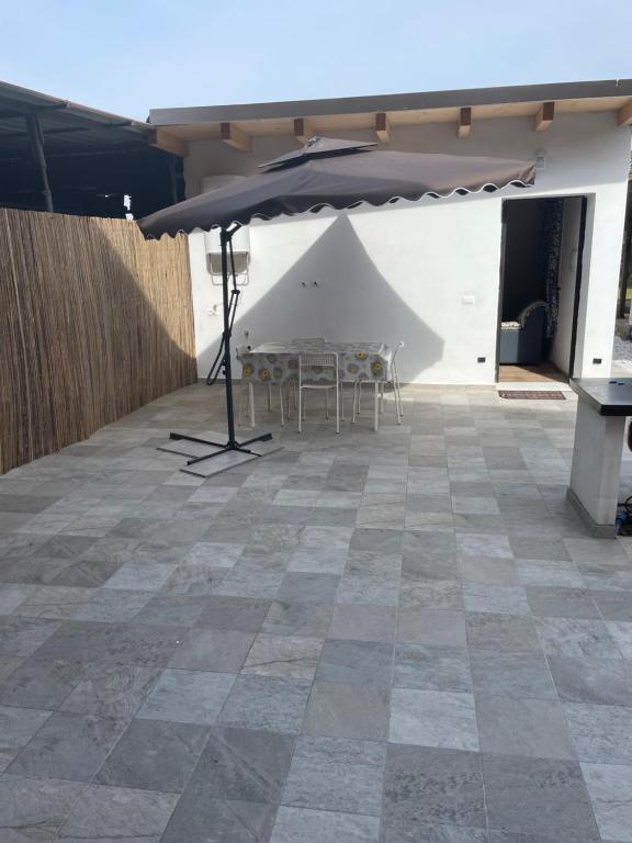 una mesa con sombrilla en el patio en La Perla Marina, en Marina di Massa