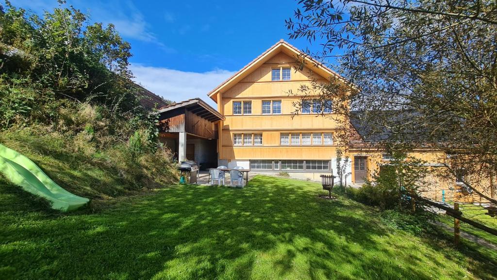 a large house with a slide in a yard at Grosses Ferienhaus für traumhafte Familienferien im Appenzellerland in Speicher