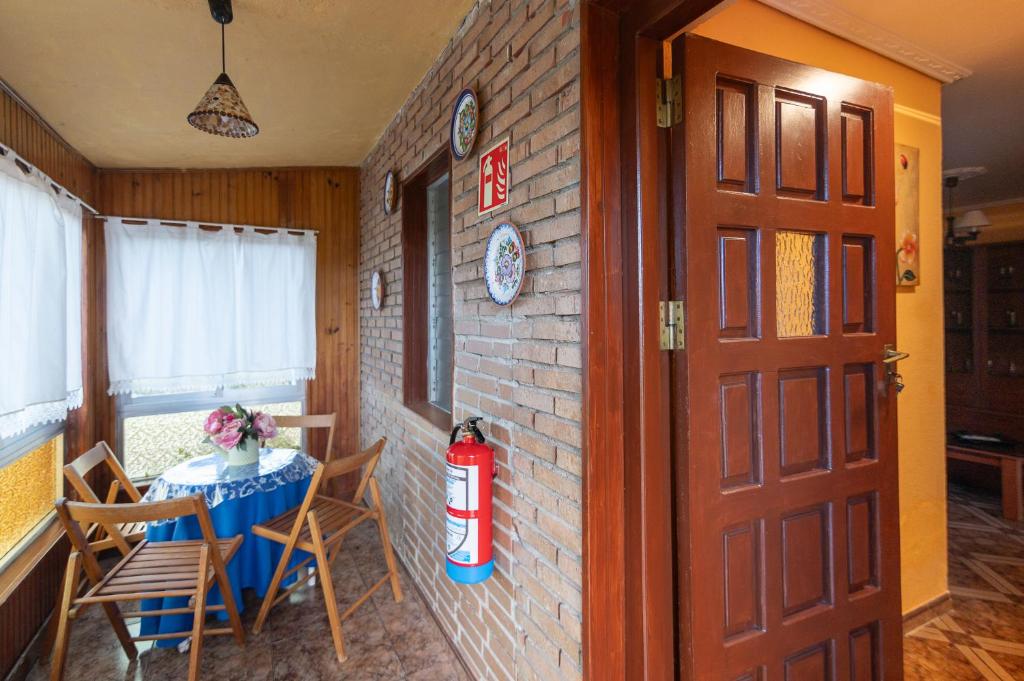 une pièce avec une table, des chaises et une borne d'incendie dans l'établissement El estanque, à Galizano