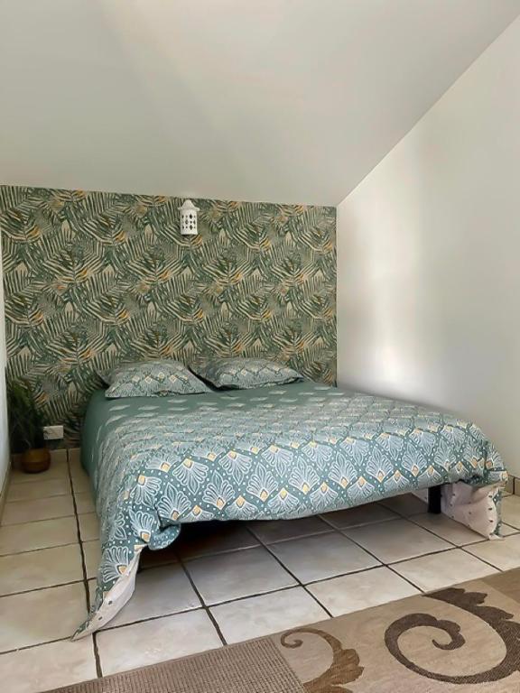 Ce lit se trouve dans une chambre dotée d'un couvre-lit vert. dans l'établissement Lok'a Life, à Villenave-dʼOrnon