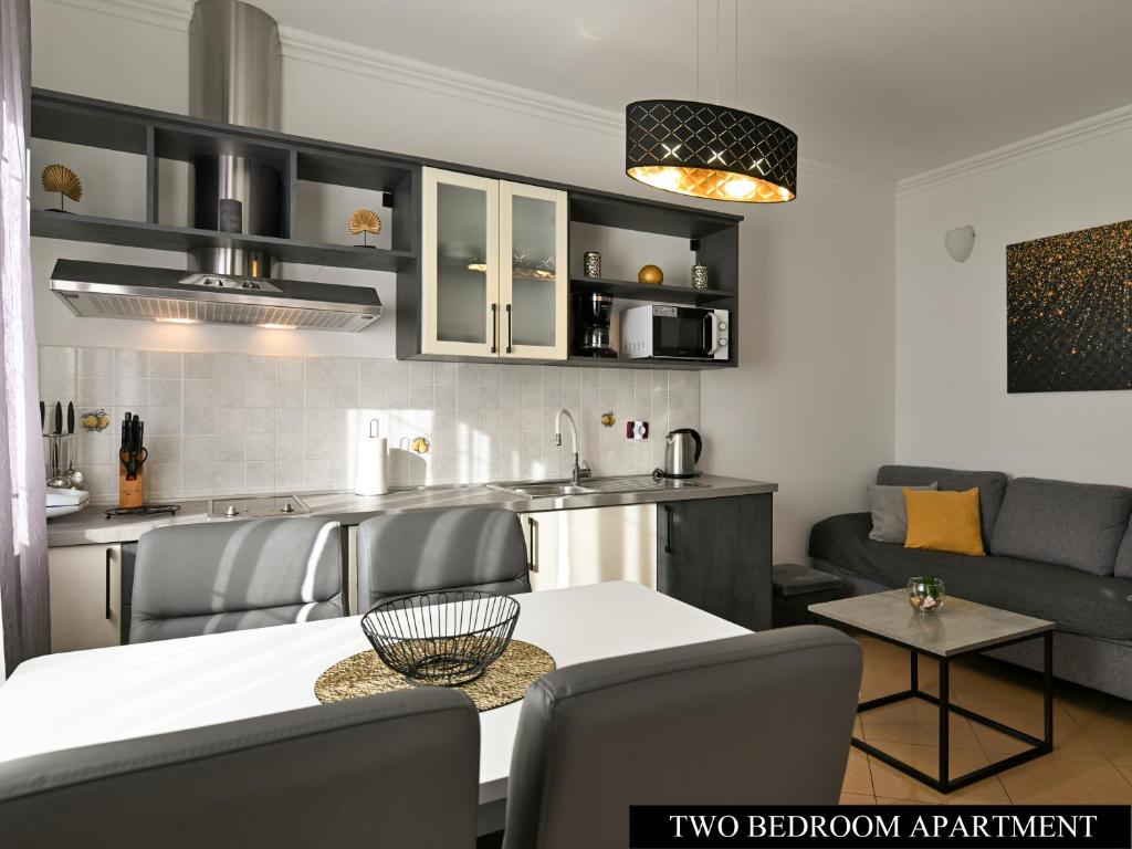 kuchnia i salon ze stołem i krzesłami w obiekcie Apartments Angela w mieście Umag