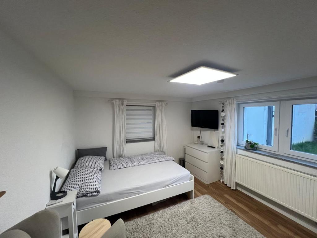 a white bedroom with a bed and a window at Zentrales & ruhiges Appartment in Schwäbisch Hall