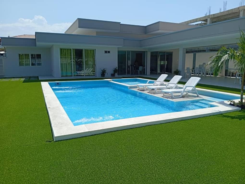 a house with a swimming pool and two lawn chairs at Sun Beach in Puerto Colombia