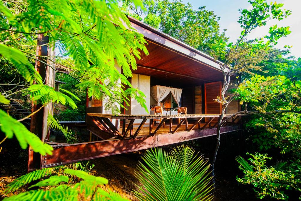 une maison dans la jungle avec une terrasse en bois dans l'établissement EcoLodge a casinha da floresta, à Morro de São Paulo