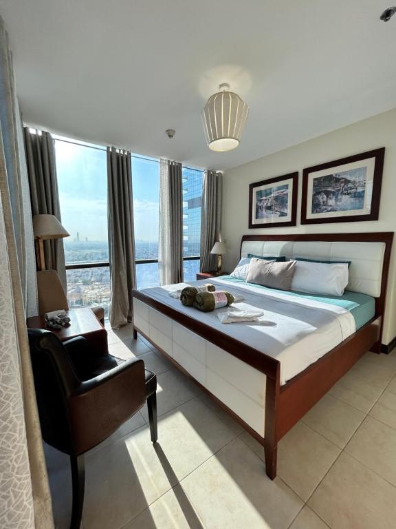 a bedroom with a large bed and a chair at Click Stay - JLT - 2 Bedroom & Balcony Lakes view Entire Apartment -AZ in Dubai