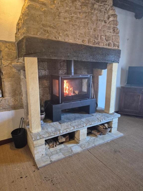 - une cheminée en pierre dans le salon dans l'établissement Havre de paix a Domme, à Domme
