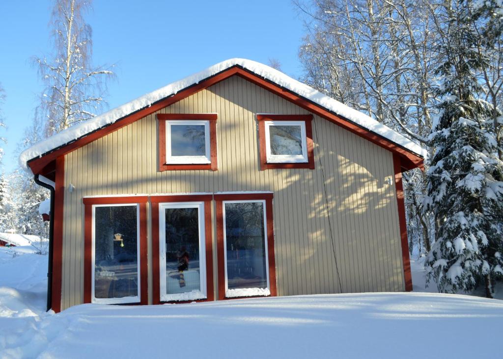 a small house with snow on the roof at Spacious home in a tranquil village setting in Ockelbo