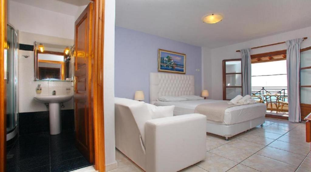 a bedroom with a bed and a bathroom with a sink at Anna Maria - Vanessa Apartments in Neo Klima