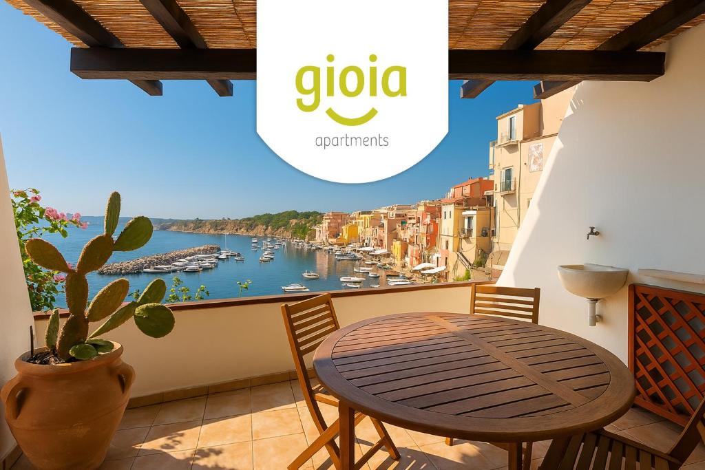 a table and chairs on a balcony with a view of a harbor at Corricella Hammok - Gioia Apartments in Procida