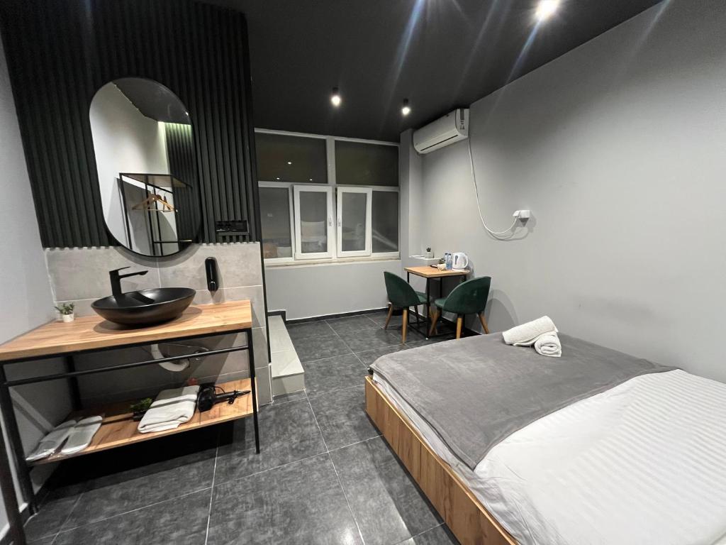 1 dormitorio con 1 cama, lavamanos y mesa en Mickitos Square One, en Skopje