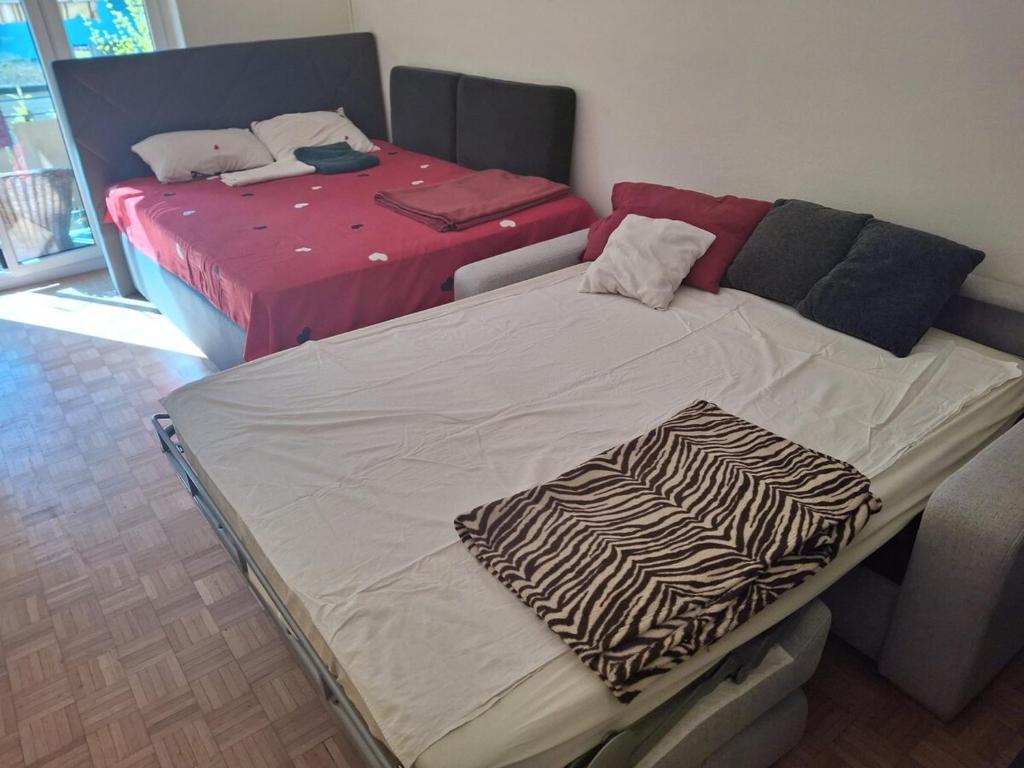 two beds sitting in a room with at Apartment in Basel Eurovision! in Basel