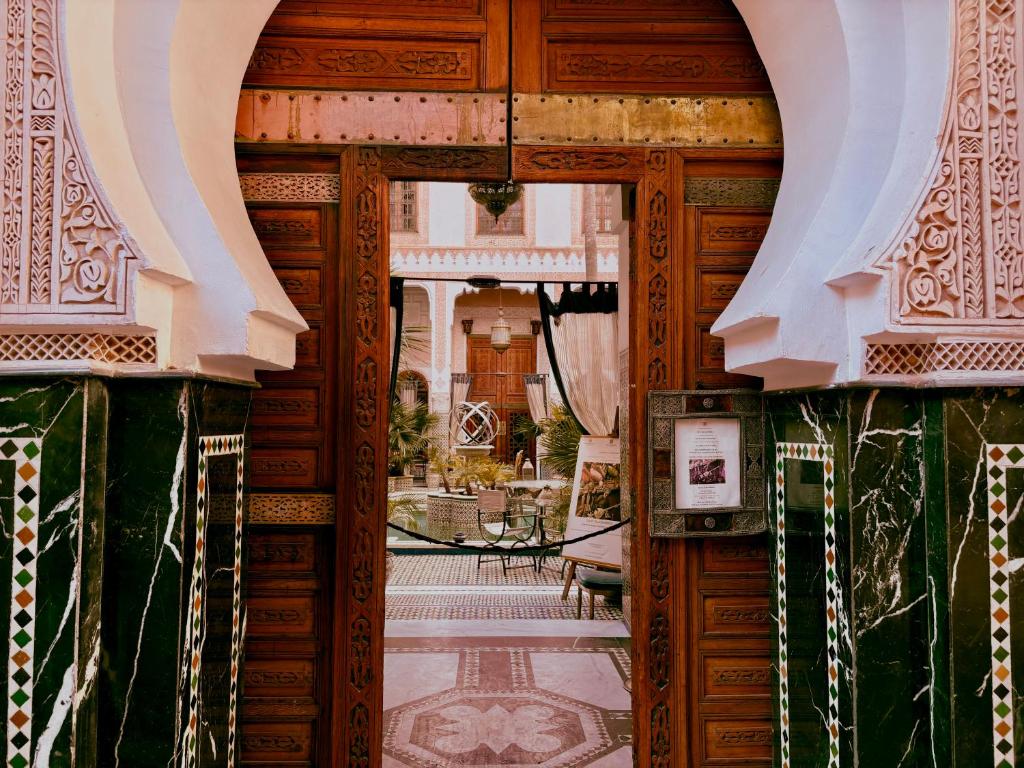 una porta aperta per una camera con tavolo di Kassr Annoujoum - Luxury Boutique Riad in the Heart of Fès Medina a Fes