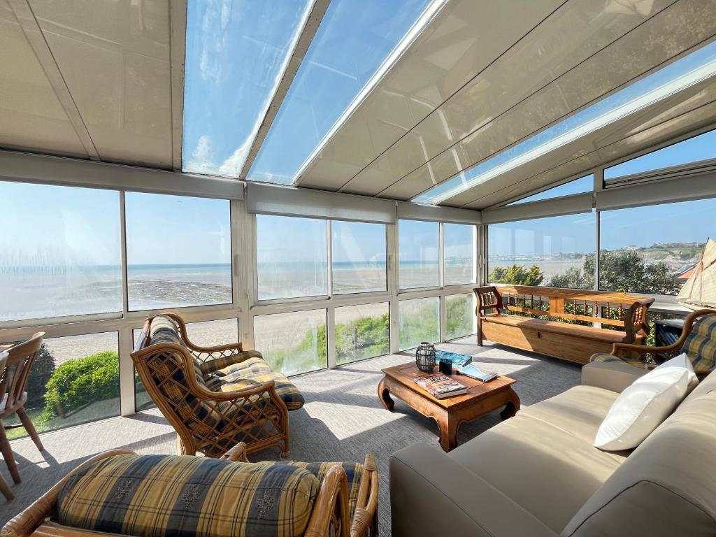 una gran sala de estar con una gran pared de cristal en La Colombière - Appartement Villa front de mer, en Granville