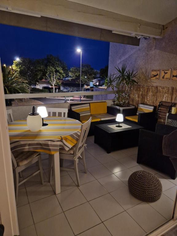 un patio avec une table et des chaises sur un toit dans l'établissement Cosy dream, au Cap d'Agde