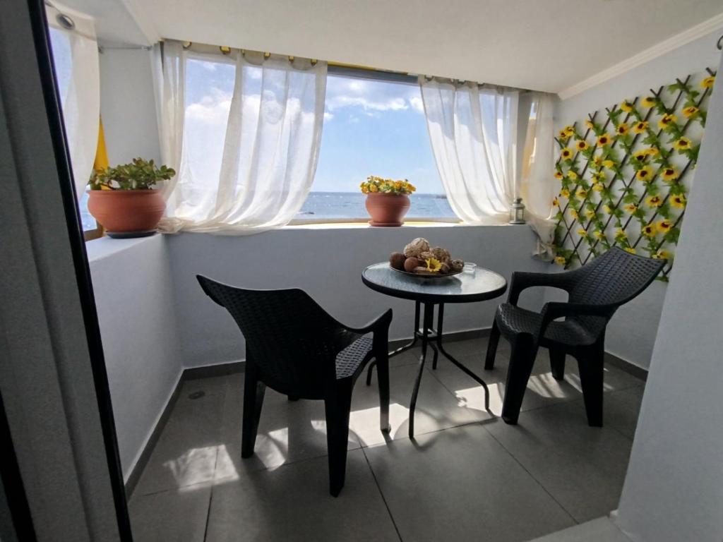 a small table and chairs in a room with a window at Anatoli in Agia Ermioni