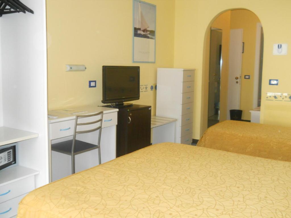 a hotel room with two beds and a television at Hotel Solemare in Albenga