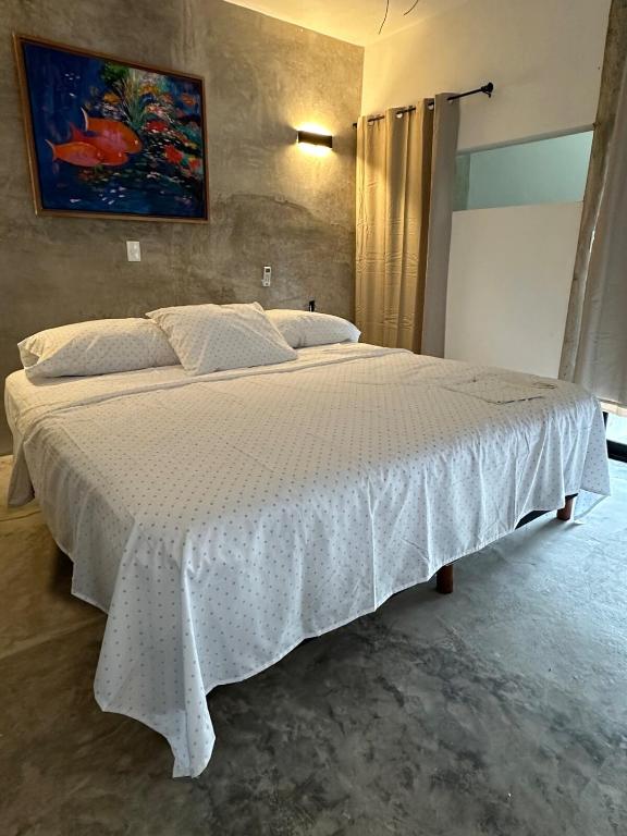 a bedroom with a large bed with a white comforter at Very quiet in Isla Mujeres