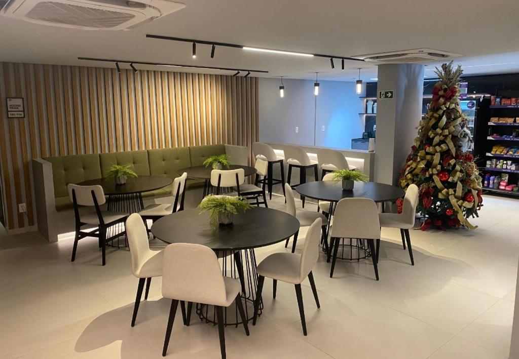a restaurant with tables and chairs and a christmas tree at Breeze flat in João Pessoa