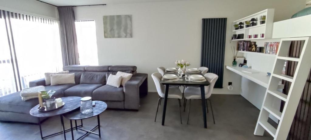ブレーデネにあるApartment Sea heated Pool with Parking - Promenade Cannes Bredeneのソファとテーブルのあるリビングルーム