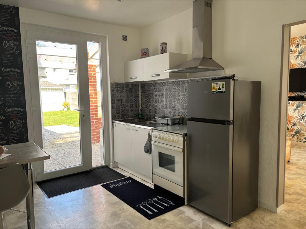 eine Küche mit Kühlschrank und Herd in der Unterkunft Chez Valentine in Grand-Fort-Philippe