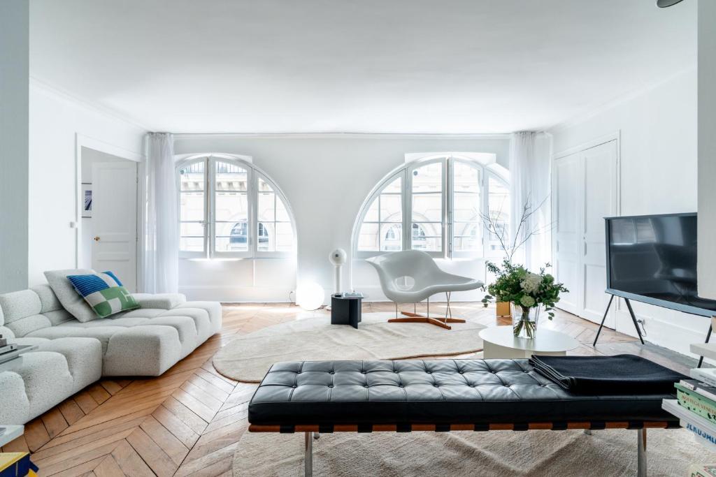 un salon avec un canapé et une télévision dans l'établissement Elégance Vendôme & Tuileries, à Paris