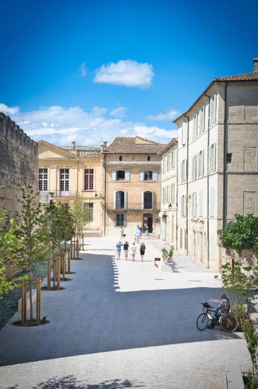un groupe de personnes assises dans une cour d'un bâtiment dans l'établissement La suite du Duché, à Uzès