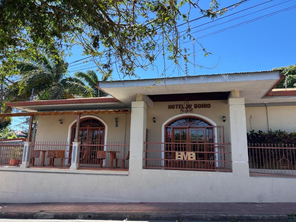 a small white house with a porch at Hotel y Restaurante Mi Bohio in Diriamba