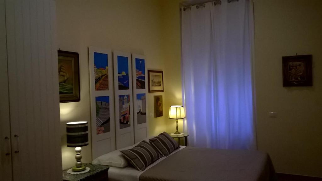 ナポリにあるLe Stanze di Angelaのベッドルーム(ベッド1台、窓、ランプ付)