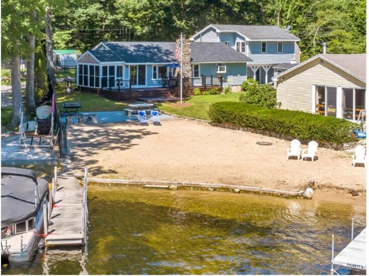a house with a marina and a boat in the water at NEW Calm Cove Retreat w Dock & Beach in Alton
