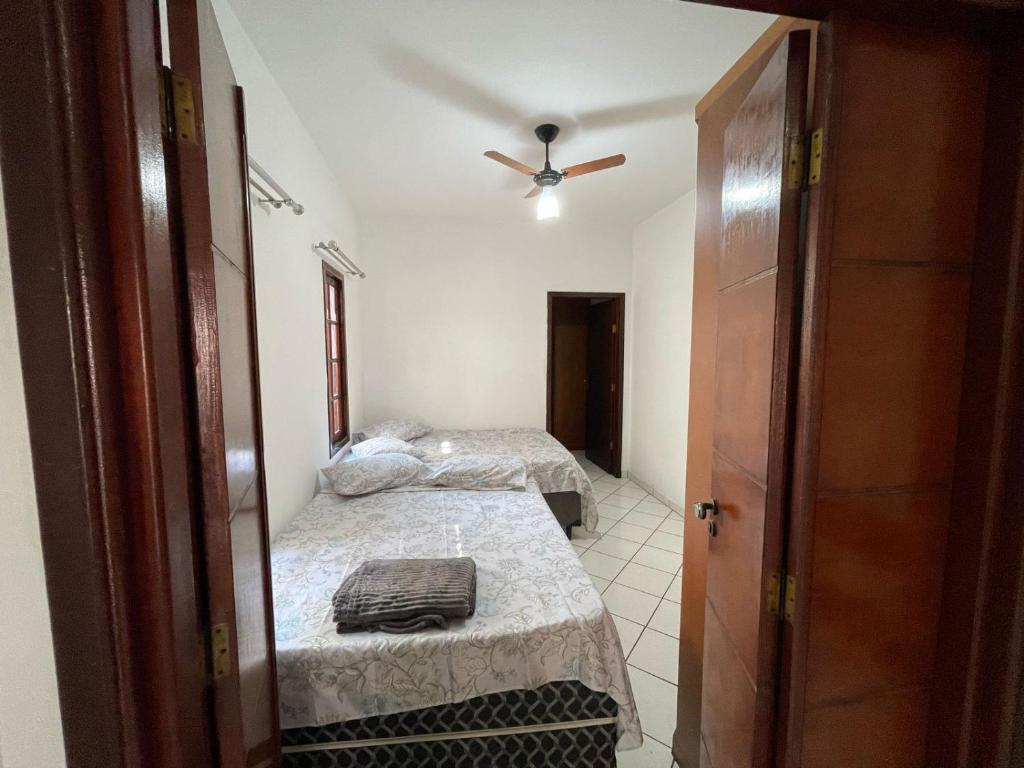 a room with two beds and a ceiling fan at Casa a 2 minutos do santuário Nossa Senhora aparecida in Aparecida