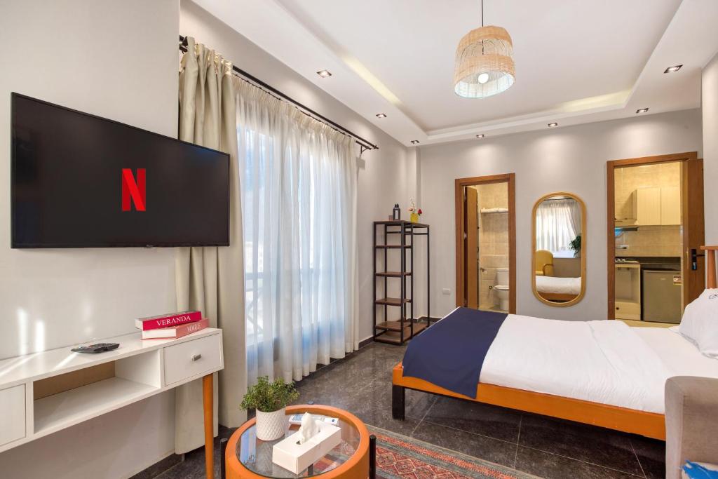 a bedroom with a bed and a tv on a wall at Travelholic AUC Residence in Cairo