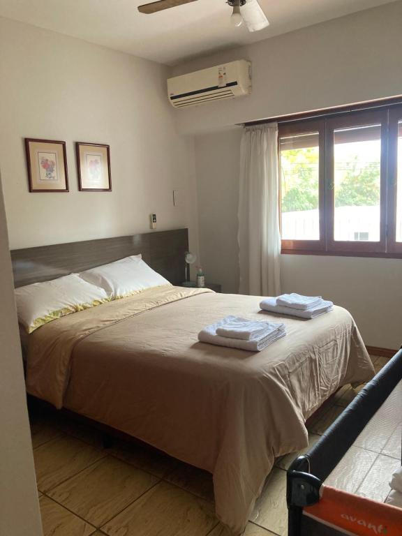 ein Schlafzimmer mit einem Bett mit zwei Handtüchern darauf in der Unterkunft Ayala Planta Alta in Santa Rosa