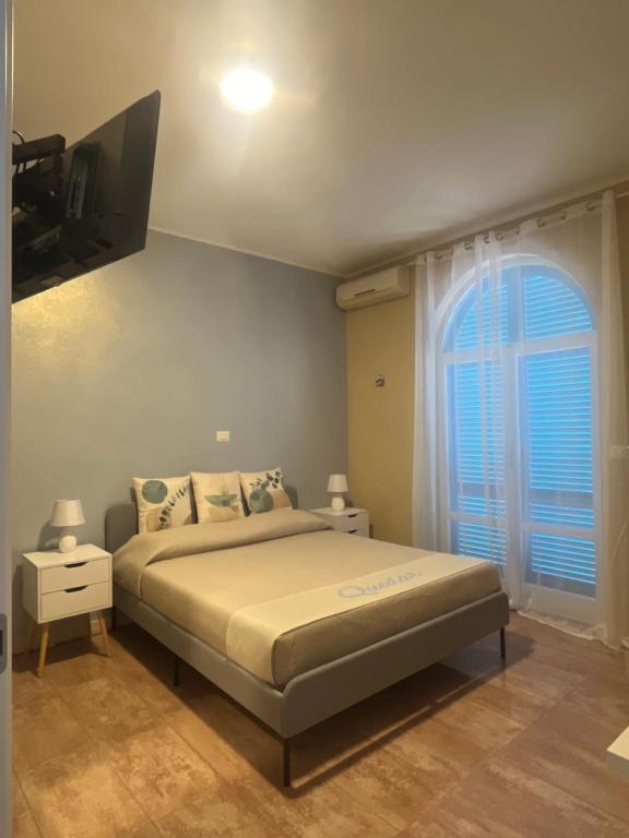 una camera da letto con un letto e una grande finestra di Residence Quedar a Melfi