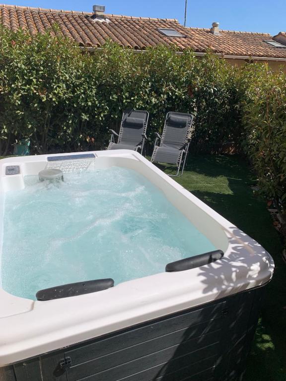 - un bain à remous dans une cour avec des chaises et des chaises dans l'établissement Mini Villa Jardin Jacuzzi, Vue mer, 300m des plages, à La Ciotat