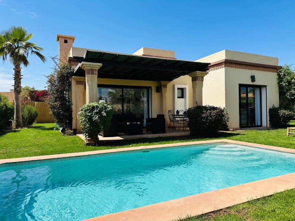 a swimming pool in front of a house at Villa 228 Dyar Shemsi in Taroudant