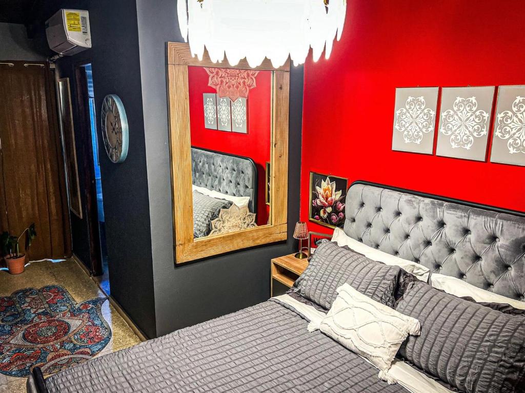 a bedroom with a bed and a red wall at ORHO HOTEL BOUTIQUE PANAMA Tocumen Airport free shuttle highway round trip 15 minuts in Tocumen
