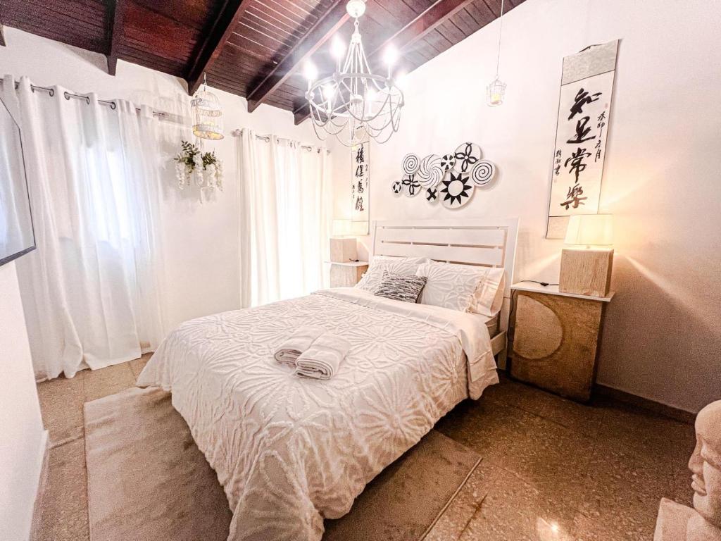 a bedroom with a white bed and a chandelier at ORHO HOTEL BOUTIQUE PANAMA Tocumen Airport free shuttle highway round trip 15 minuts in Tocumen