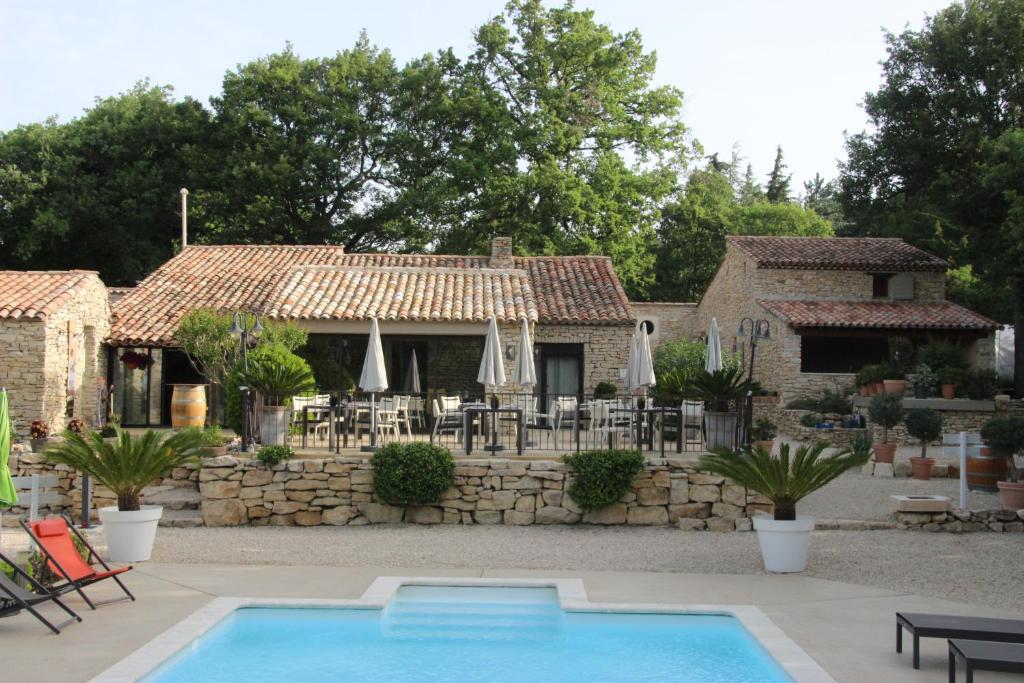 une maison avec une piscine devant dans l'établissement Les Chambres du Hameau, à Gordes