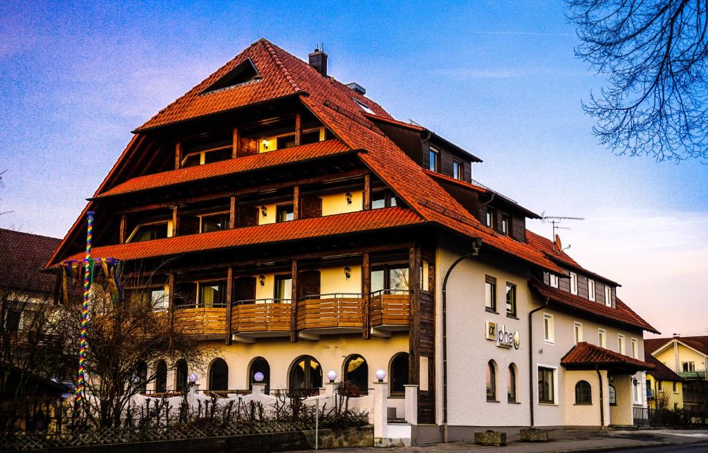 duży budynek z pomarańczowym dachem w obiekcie Hotel-Restaurant Alpha w mieście Friedrichshafen