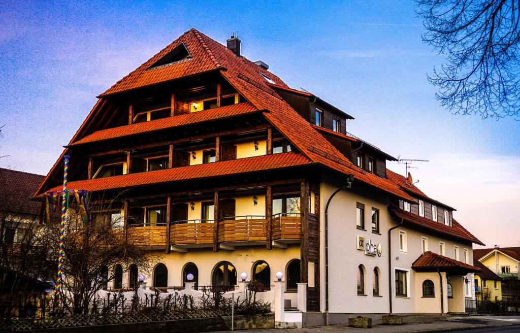 a large building with an orange roof at Hotel-Restaurant Alpha in Friedrichshafen