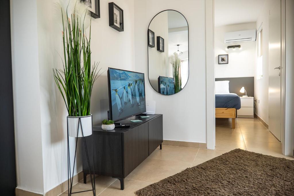 a living room with a television and a mirror at Stella & Rosie - Two Bedroom Apartment's by ELDI in Pieta
