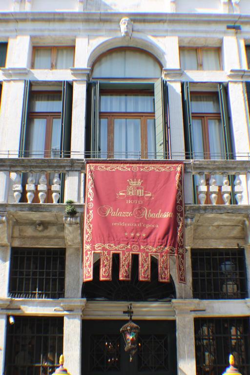 a red banner on the side of a building at Hotel Palazzo Abadessa in Venice